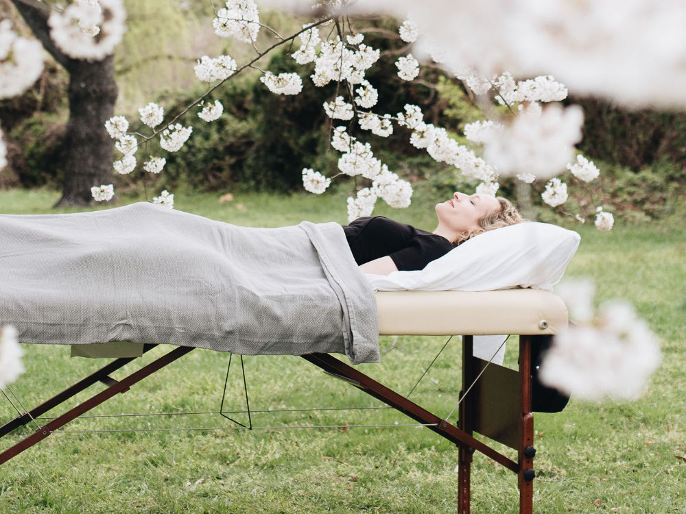 patient on treatment table in field of cherry blossoms